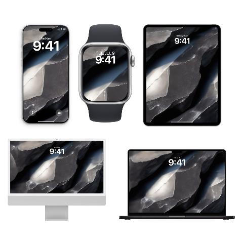 A set of five Apple devices including an iPhone, Apple Watch, iPad, iMac, and MacBook displaying matching raw titanium and graphite stone textured wallpapers.